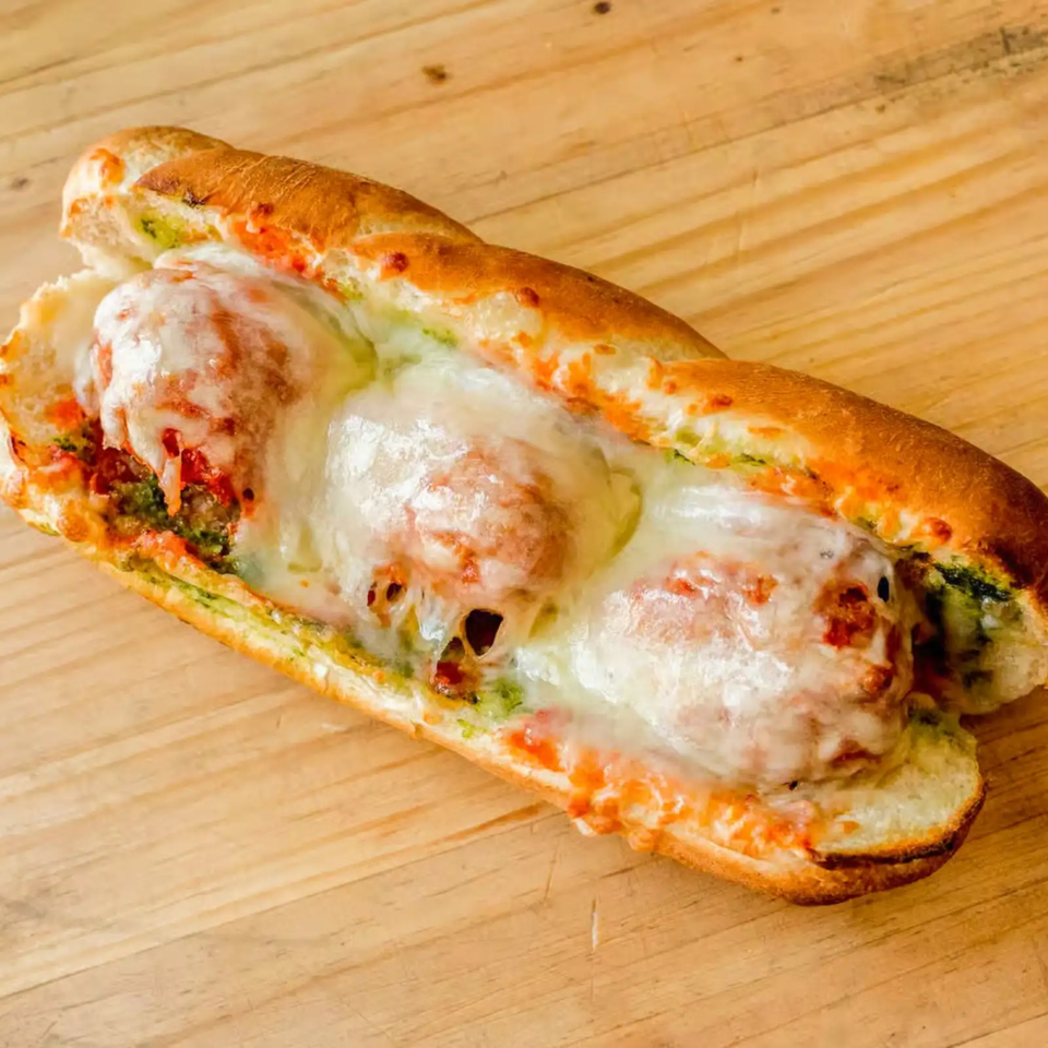 Totally Baked Pizza's meatball sub with melted mozzarella cheese, pesto, and marinara sauce.